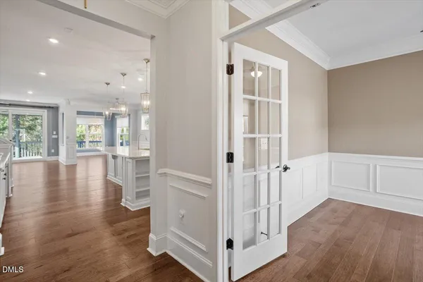 a view of a hallway with wooden floor and a living room
