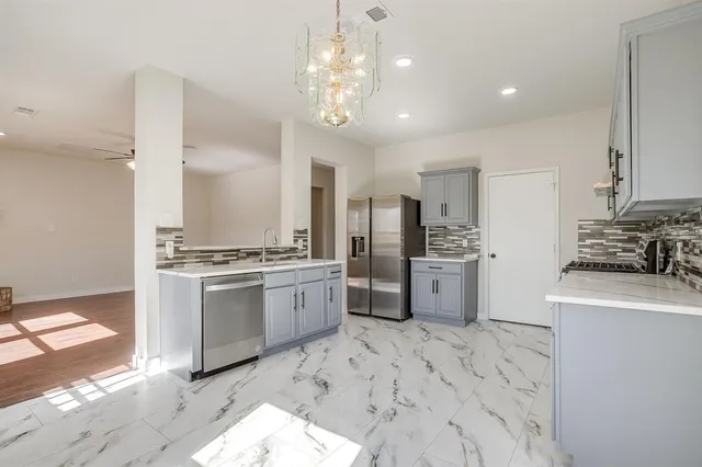 a kitchen with stainless steel appliances granite countertop a sink stove and refrigerator
