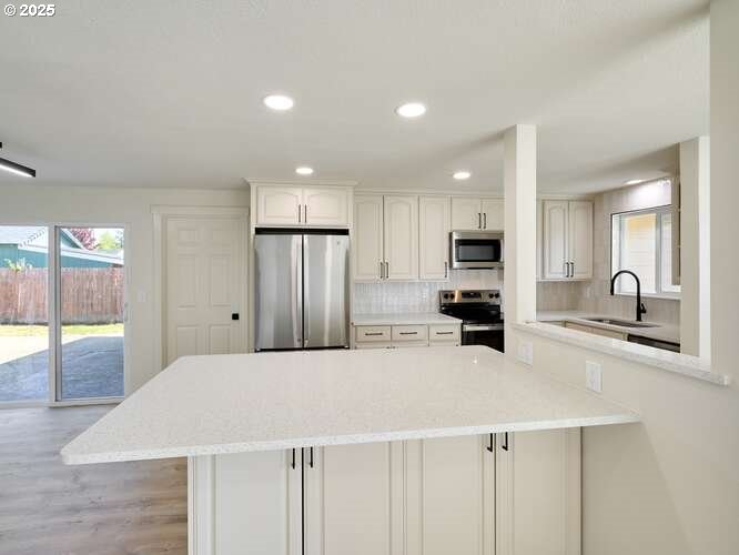 175 7th Street Gervais, OR 97026 - Photo 13 of 24 a kitchen with stainless steel appliances kitchen island sink refrigerator and cabinets