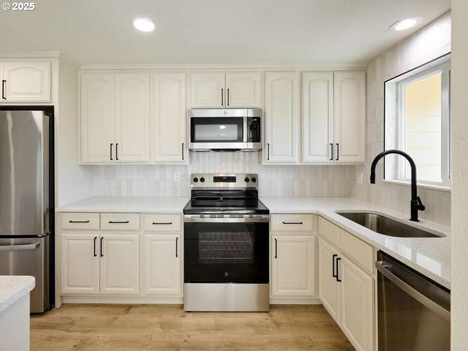 175 7th Street Gervais, OR 97026 - Photo 15 of 24 a kitchen with white cabinets sink and stainless steel appliances