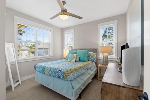 a bedroom with a large bed and windows