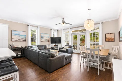a living room with furniture a flat screen tv and wooden floor