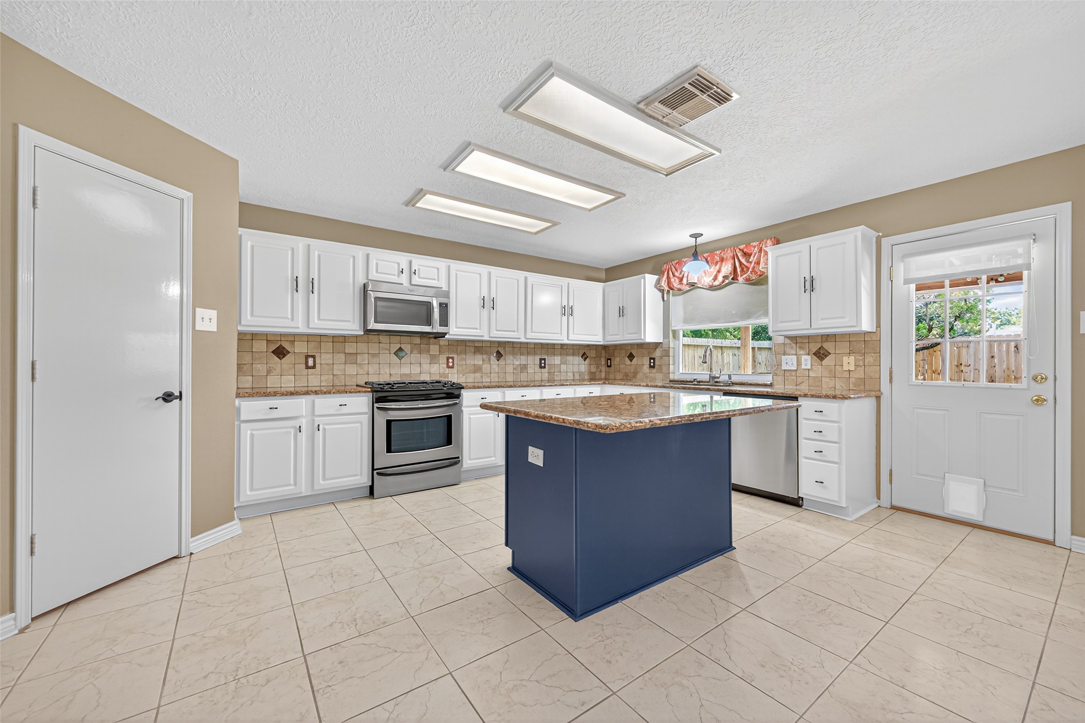 a large kitchen with cabinets and stainless steel appliances