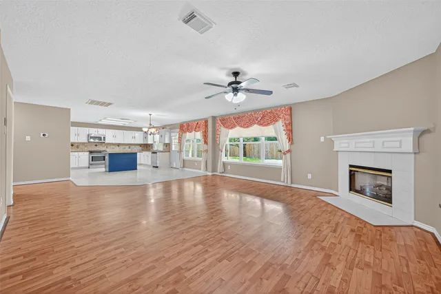 a view of an empty room with a fireplace and a window