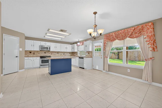 a large kitchen with cabinets and stainless steel appliances