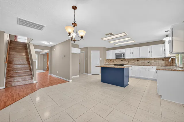 a large kitchen with stainless steel appliances granite countertop a stove a sink dishwasher and a refrigerator