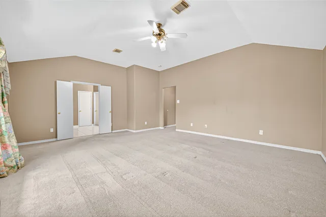 a view of an empty room with a ceiling fan