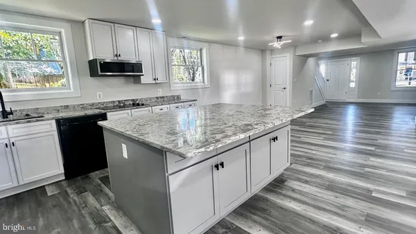 a kitchen with granite countertop a sink stainless steel appliances and cabinets