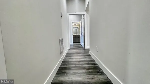 a view of a hallway with wooden floor and closet
