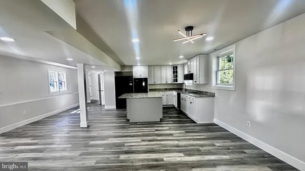 a kitchen with kitchen island stainless steel appliances a stove a sink a refrigerator and cabinets