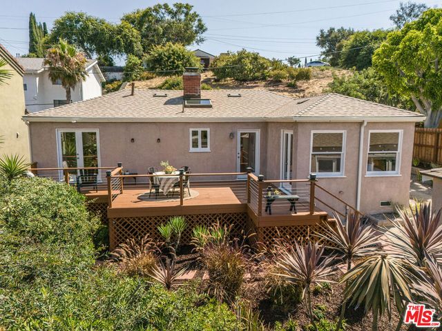 a view of a patio with table and chairs potted plants and large tree