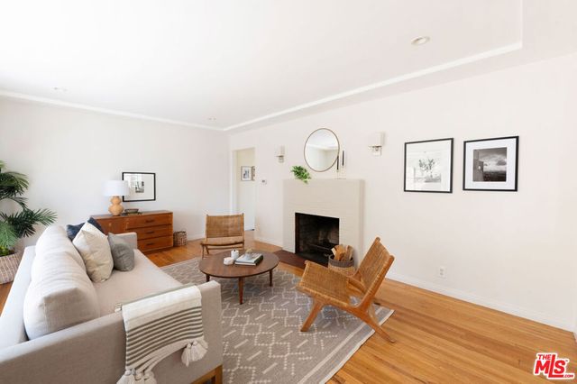 a living room with furniture a fireplace and a wooden floor