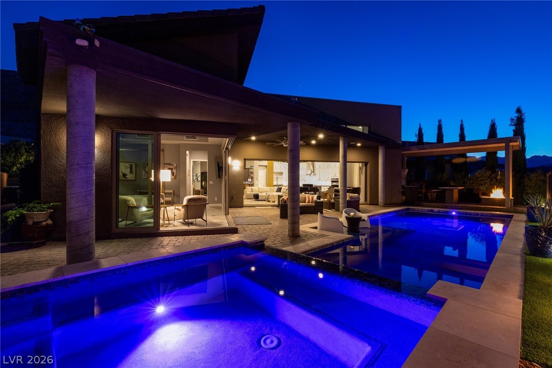 6014 Willow Ridge Court Las Vegas, NV 89135 - Photo 94 of 99 An inviting backyard oasis offers ample space for relaxation and enjoyment, with a sparkling pool under the evening sky.