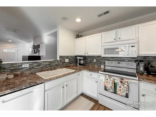 a kitchen with granite countertop a sink a stove and cabinets