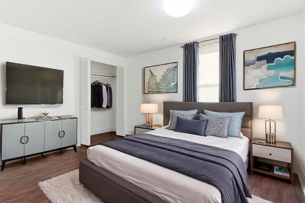 90 Brooks Street, Unit 90 Boston, MA 02128 - Photo 4 of 9 a bedroom with a large bed and flat tv screen on the dresser