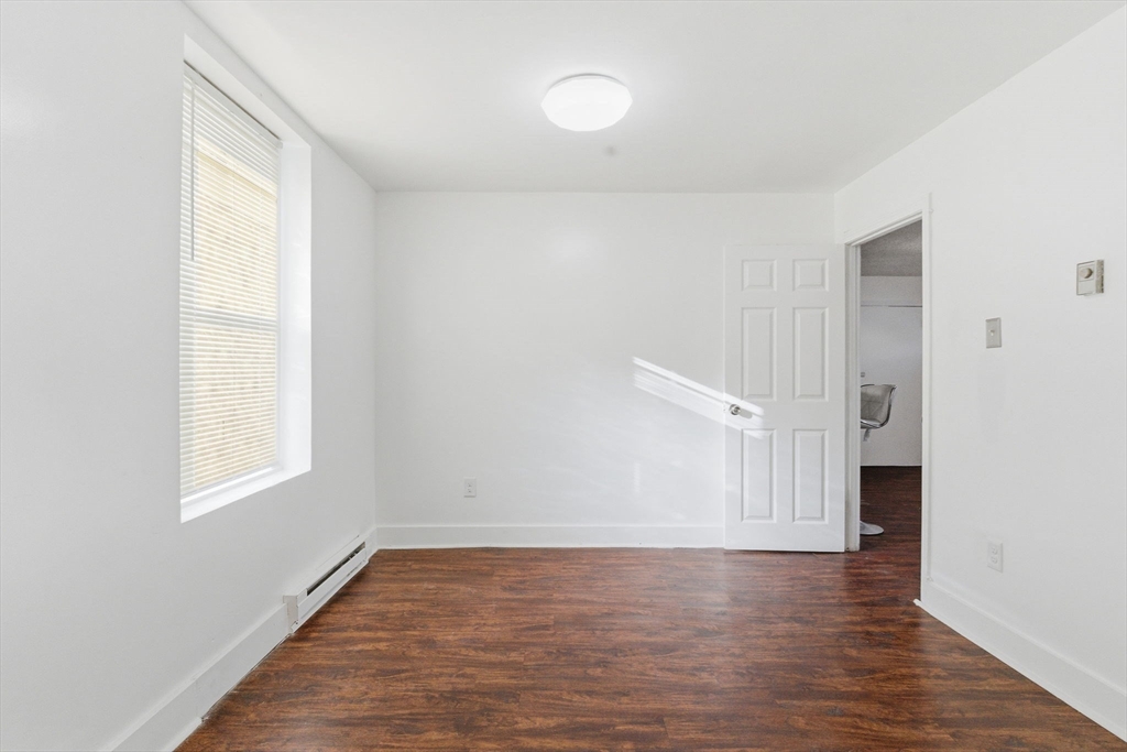 90 Brooks Street, Unit 90 Boston, MA 02128 - Photo 5 of 9 a view of an empty room with wooden floor and a window