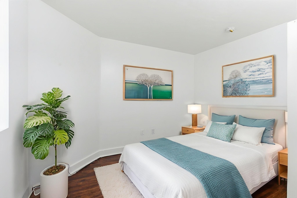 90 Brooks Street, Unit 90 Boston, MA 02128 - Photo 7 of 9 a bedroom with a bed a painting on the wall and a potted plant