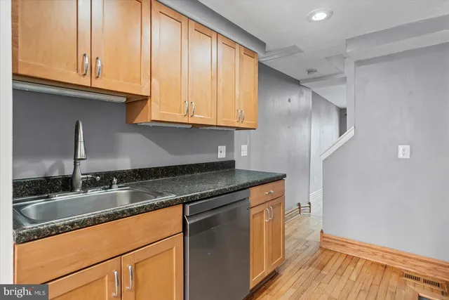 a kitchen with granite countertop stainless steel appliances a sink and cabinets