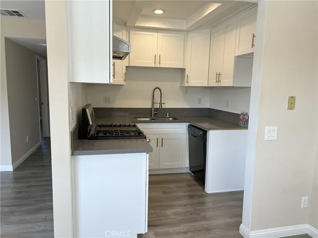 a kitchen with stainless steel appliances granite countertop a white stove top oven and white cabinets