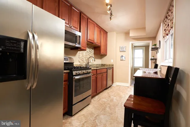 a kitchen with stainless steel appliances granite countertop a refrigerator a stove a sink and a microwave