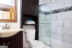 a bathroom with a sink a toilet and shower