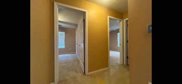 a view of a hallway with a chandelier fan