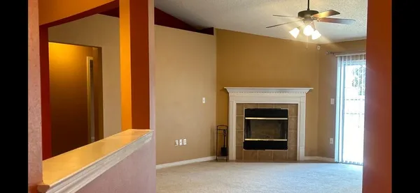 a view of a livingroom with a chandelier fan and a fireplace