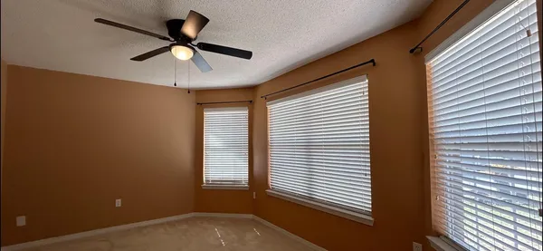 a view of a room with a ceiling fan and a window