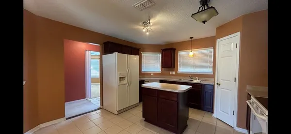 a kitchen with stainless steel appliances granite countertop a sink and a refrigerator
