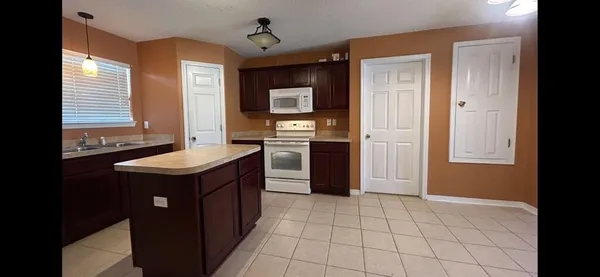 a kitchen with a sink a refrigerator and cabinets
