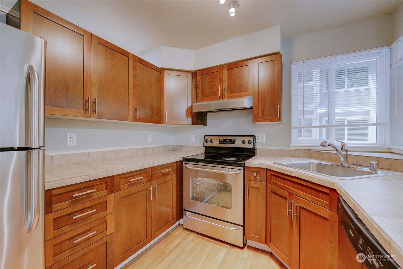3908 243rd Place Southeast, Unit Q202 Bothell, WA 98021 - Photo 12 of 40 a kitchen with stainless steel appliances granite countertop a sink stove and refrigerator