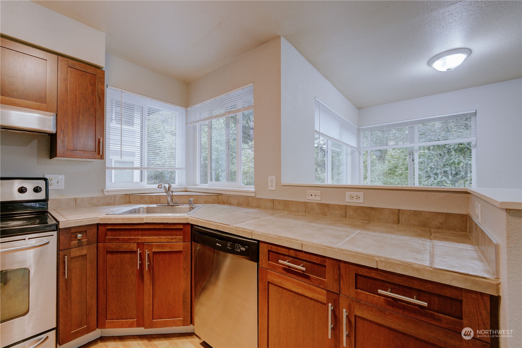 3908 243rd Place Southeast, Unit Q202 Bothell, WA 98021 - Photo 13 of 40 a kitchen with granite countertop cabinets sink and window