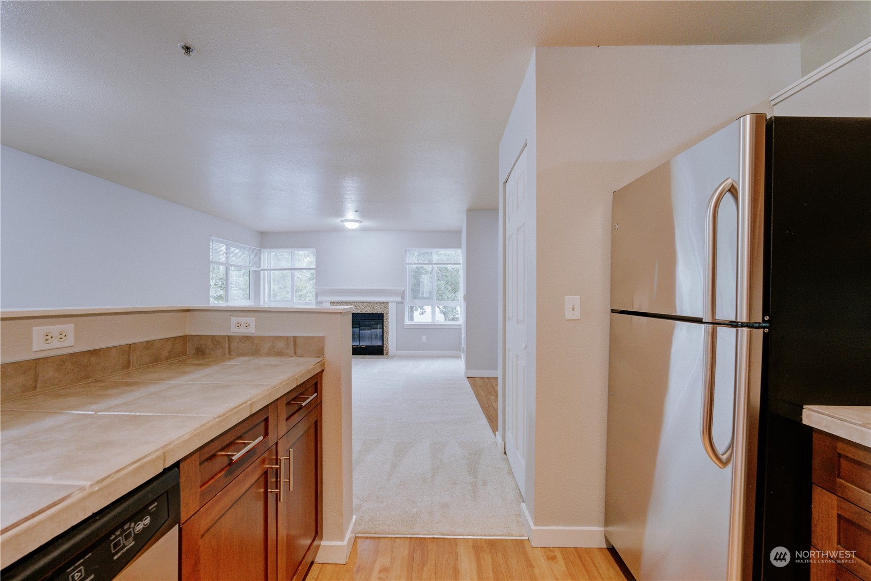 3908 243rd Place Southeast, Unit Q202 Bothell, WA 98021 - Photo 15 of 40 a kitchen with a refrigerator a sink and a stove top oven