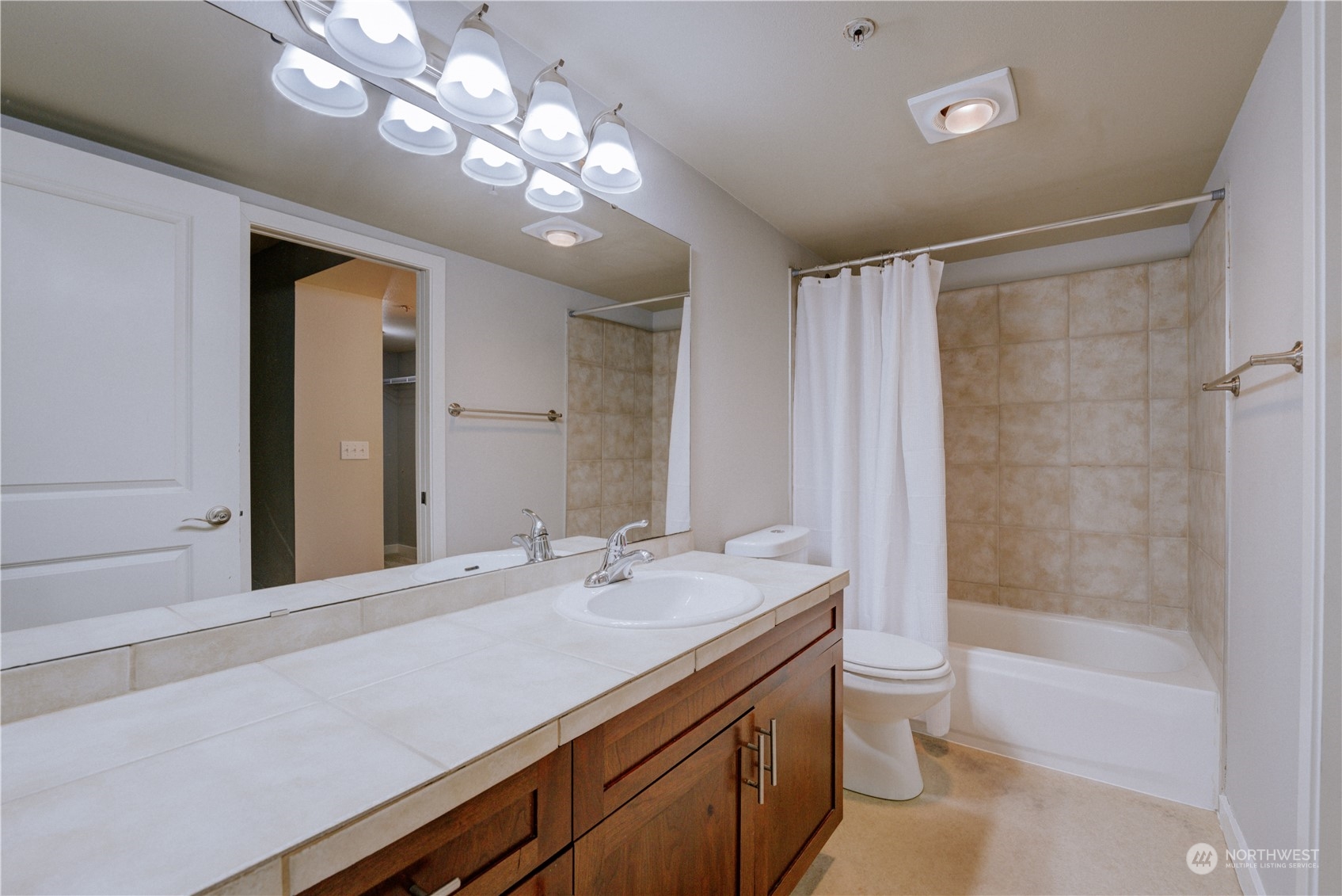 3908 243rd Place Southeast, Unit Q202 Bothell, WA 98021 - Photo 23 of 40 a bathroom with a granite countertop sink a toilet and shower