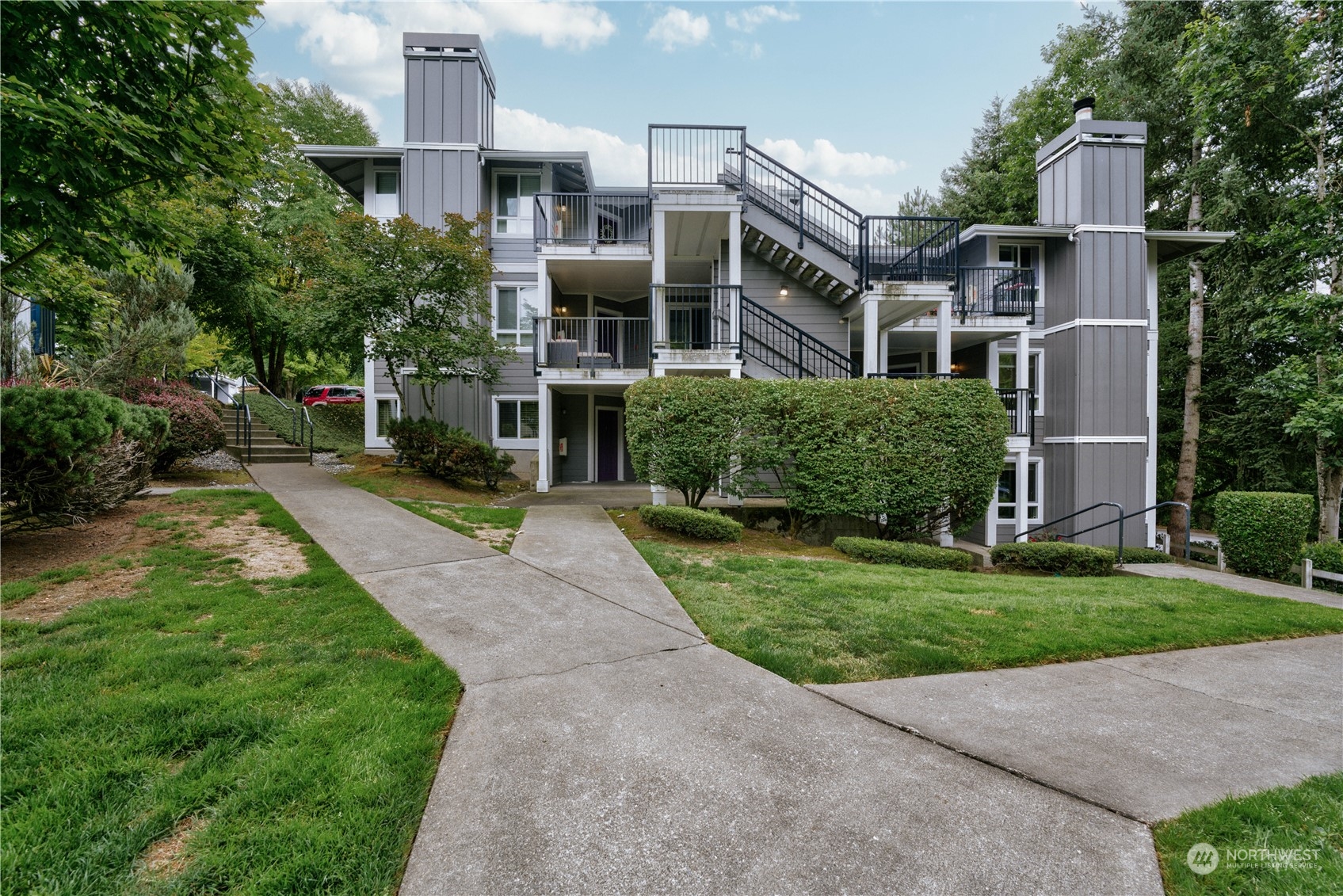 3908 243rd Place Southeast, Unit Q202 Bothell, WA 98021 - Photo 33 of 40 a front view of a house with a yard and trees
