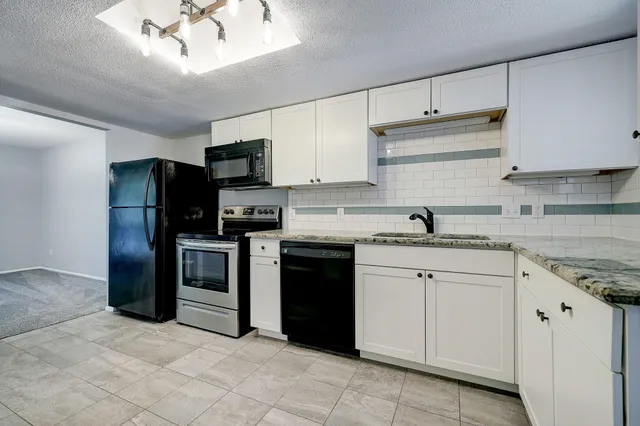 a kitchen with granite countertop cabinets and steel stainless steel appliances