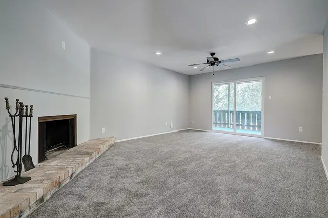 a view of an empty room with a fireplace and a window