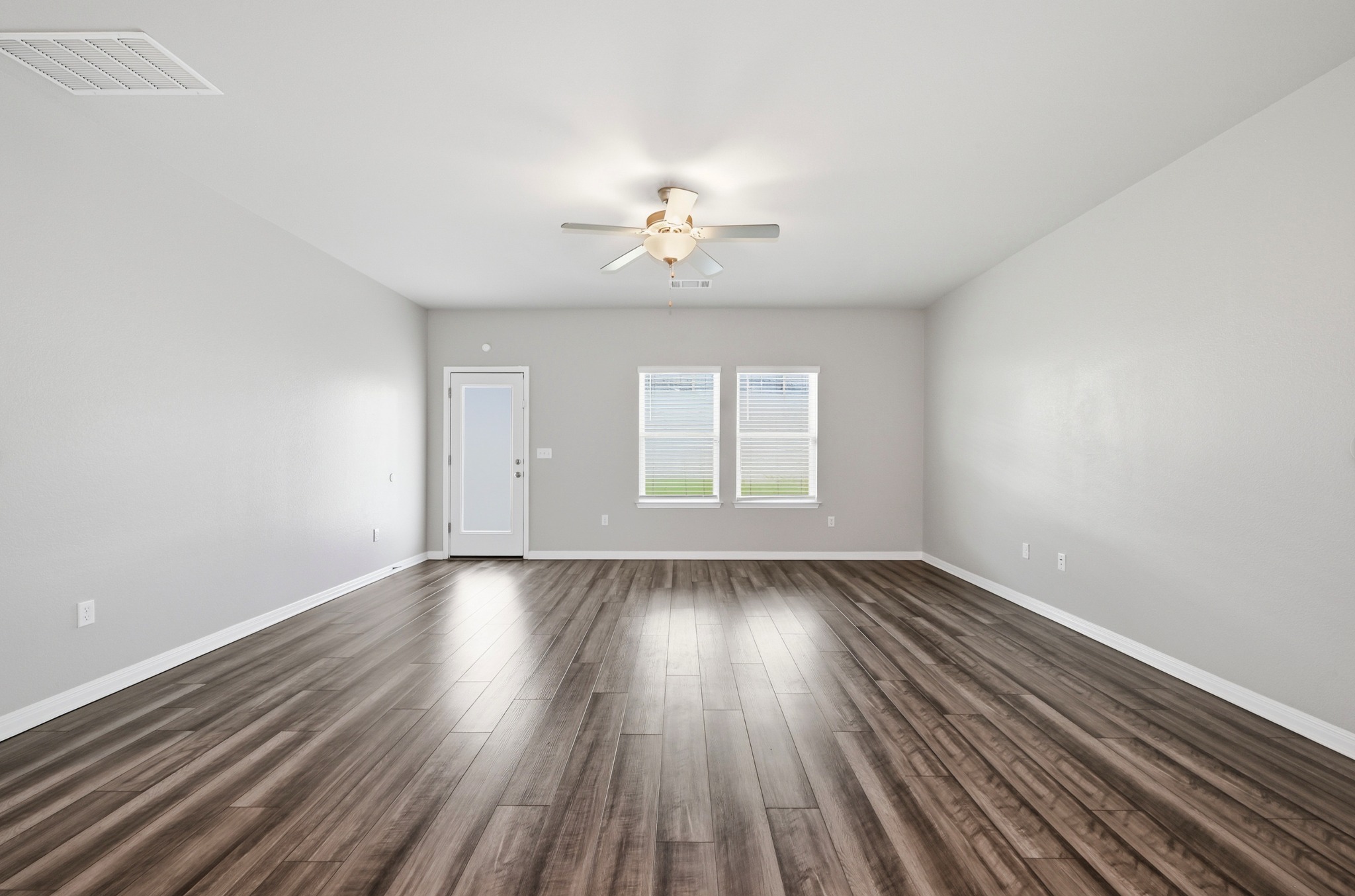 12606 Dairywork Road Buda, TX 78610 - Photo 11 of 32 a view of an empty room with wooden floor and a window