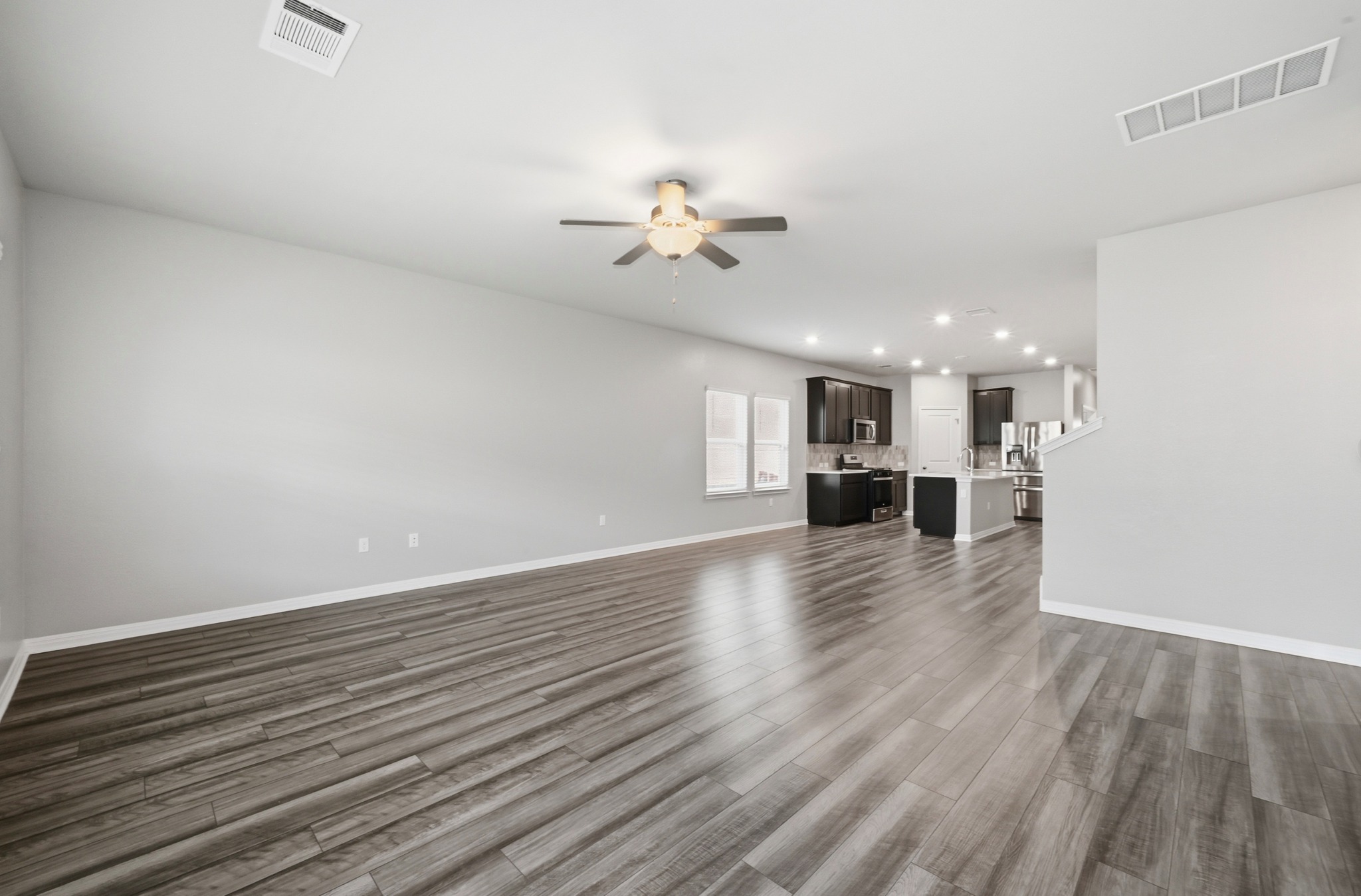 12606 Dairywork Road Buda, TX 78610 - Photo 14 of 32 wooden floor in an empty room with a kitchen