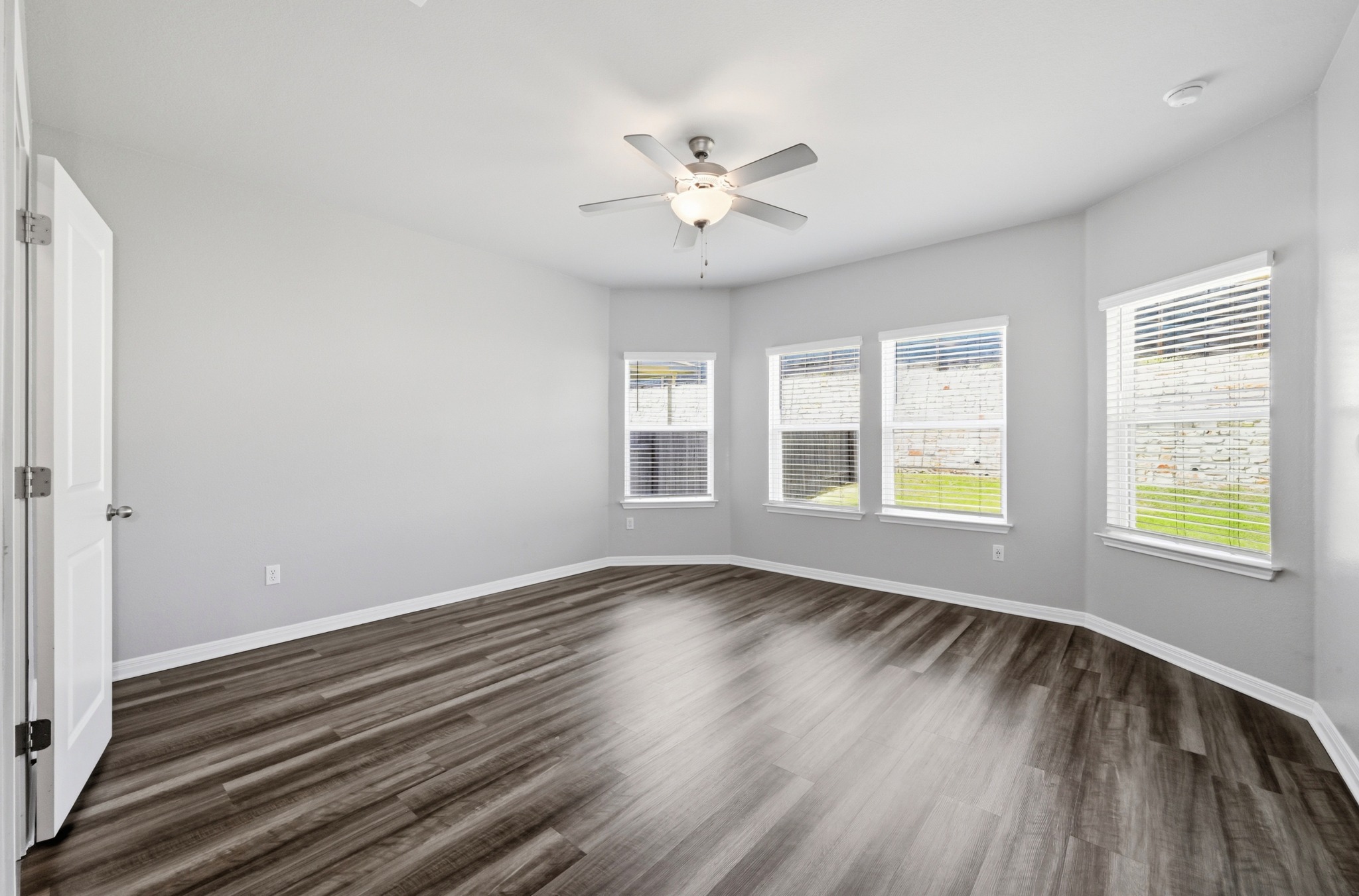12606 Dairywork Road Buda, TX 78610 - Photo 15 of 32 a view of an empty room with wooden floor and a window