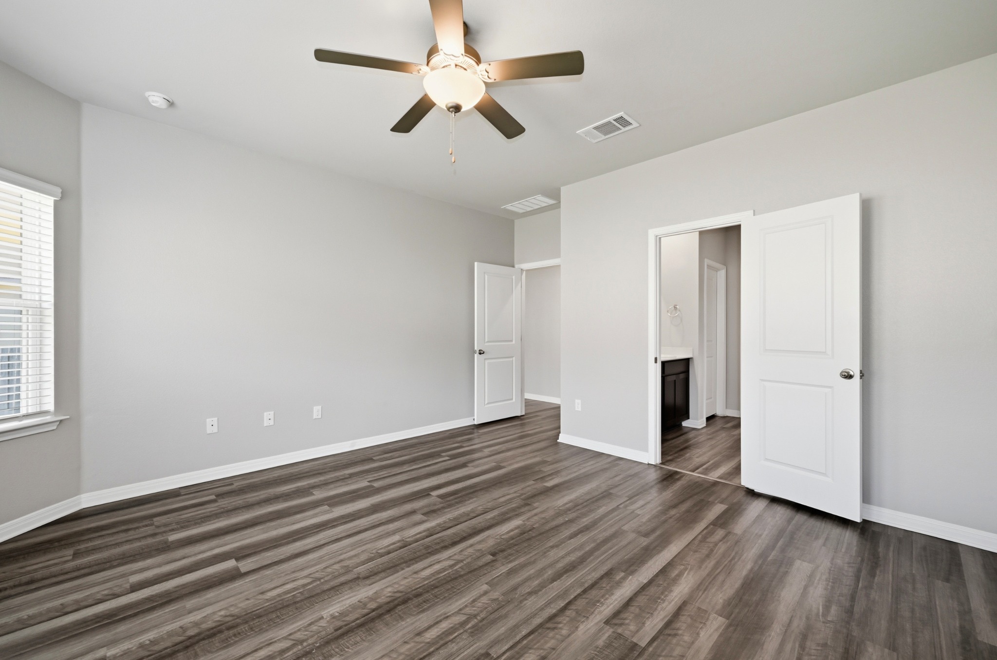 12606 Dairywork Road Buda, TX 78610 - Photo 16 of 32 an empty room with wooden floor ceiling fan and window