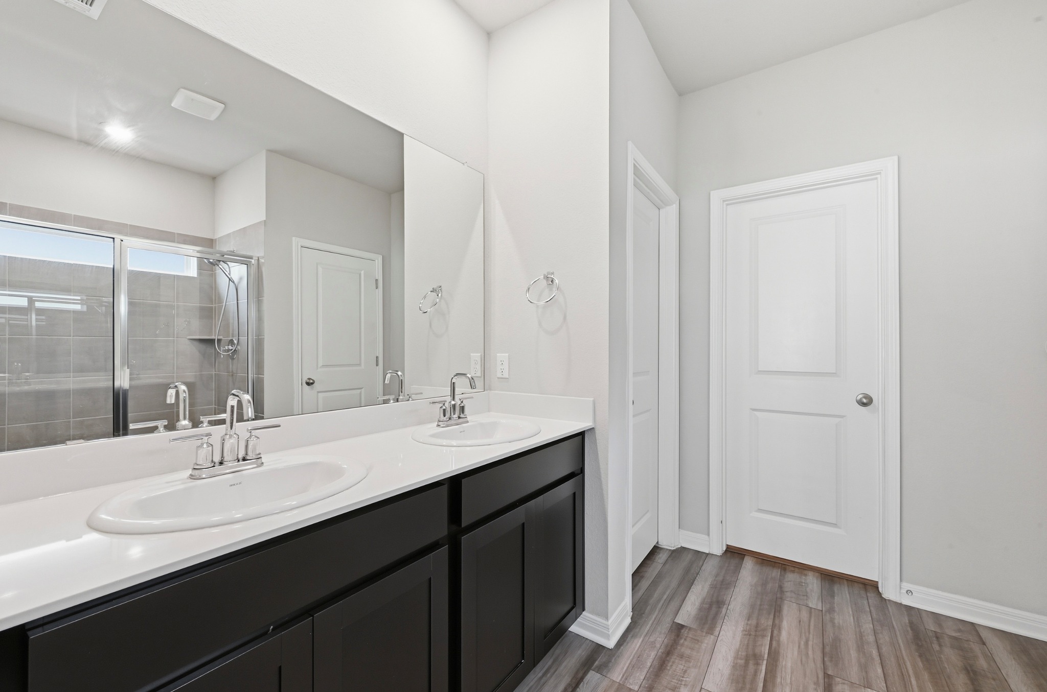 12606 Dairywork Road Buda, TX 78610 - Photo 17 of 32 a bathroom with a double vanity sink and mirror