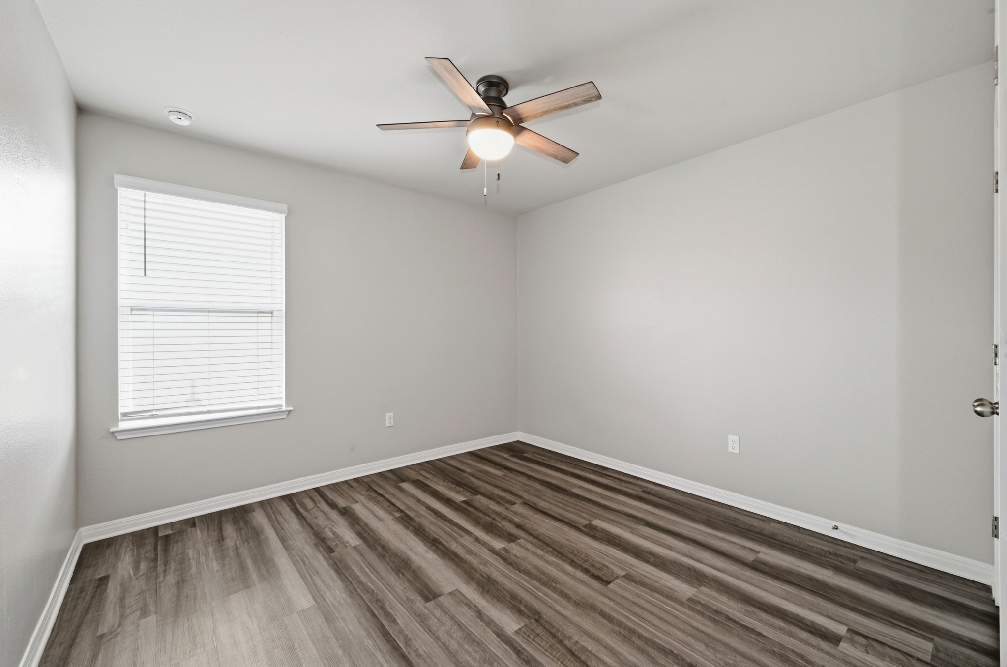 12606 Dairywork Road Buda, TX 78610 - Photo 26 of 32 an empty room with wooden floor and windows