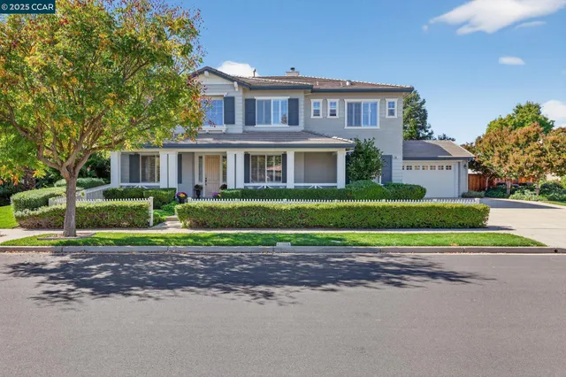 a front view of a house with a yard and trees