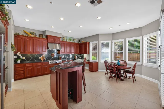 a kitchen with stainless steel appliances granite countertop sink stove and wooden cabinets