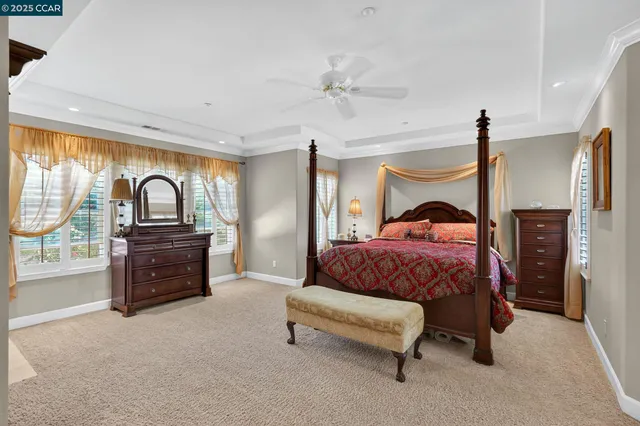 a bedroom with a bed and a dresser next to a window