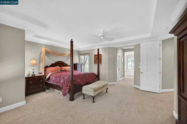 a spacious bedroom with a bed and a chandelier