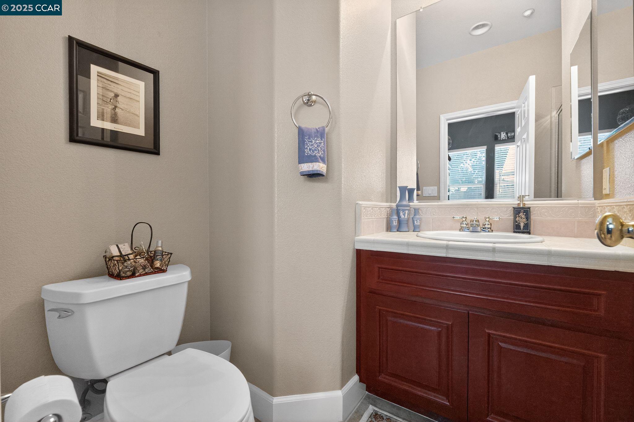 255 Prato Way Livermore, CA 94550 - Photo 37 of 45 a bathroom with a toilet a sink and mirror
