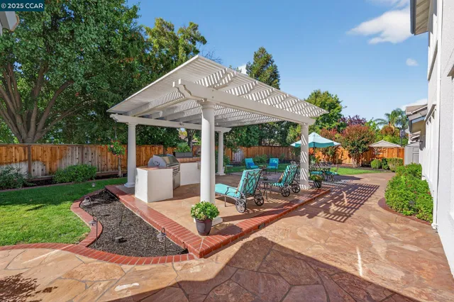 a view of a patio with table and chairs under an umbrella