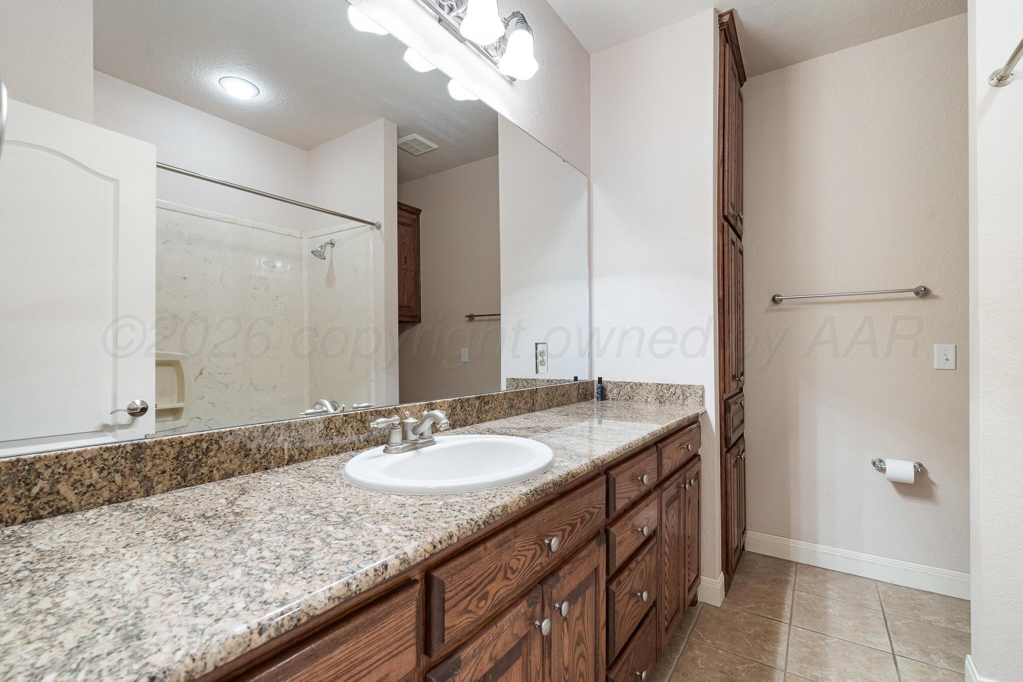 5008 Wesley Road Amarillo, TX 79119 - Photo 37 of 47 a bathroom with a granite countertop sink and a mirror